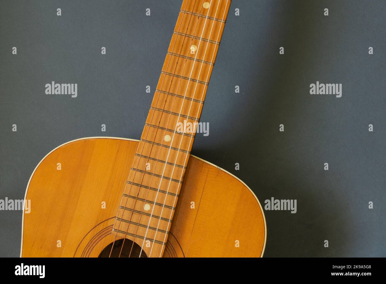chitarra marrone in legno su sfondo scuro Foto Stock