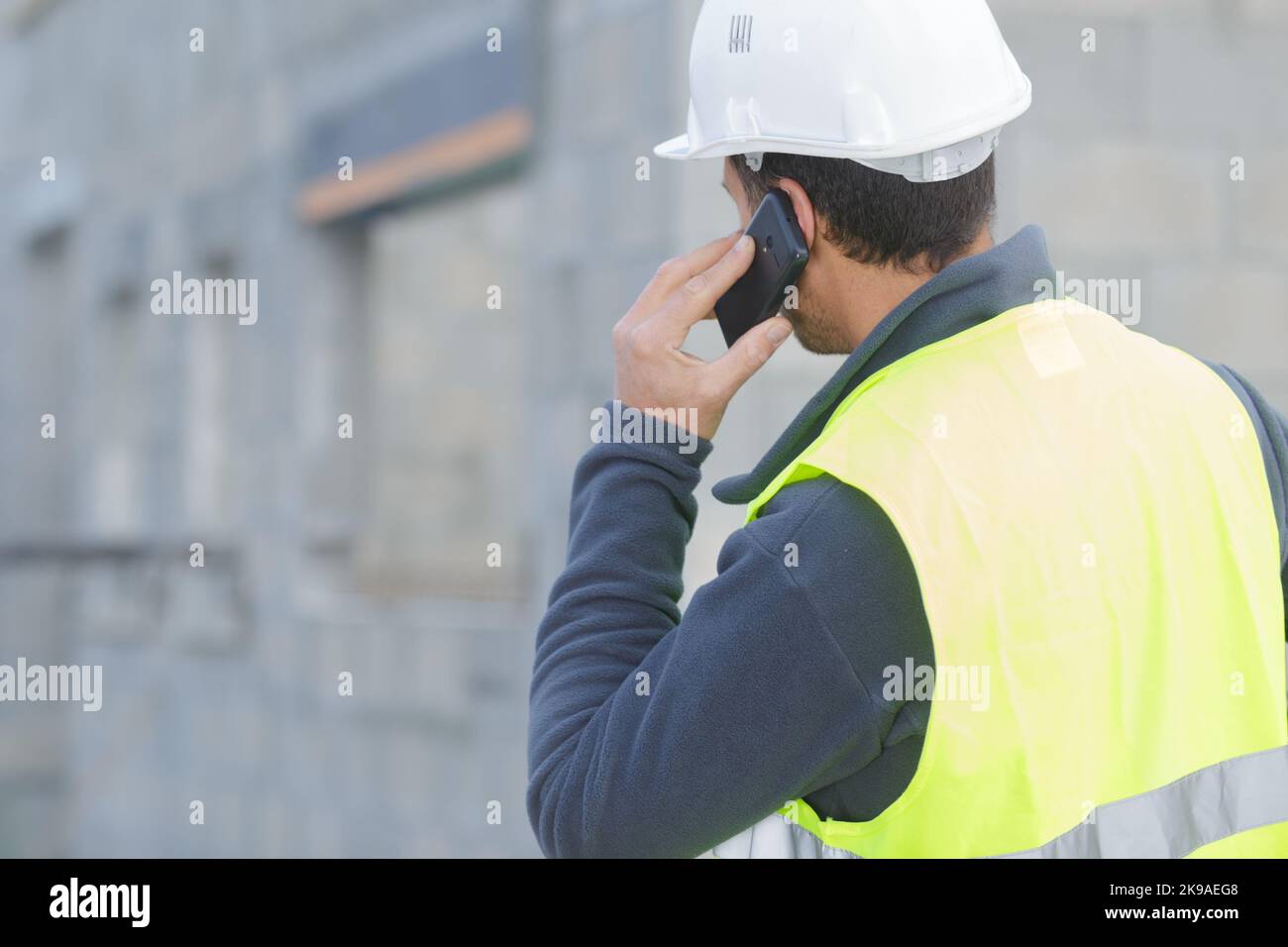 creazione di chiamate tramite smartphone in un cantiere Foto Stock