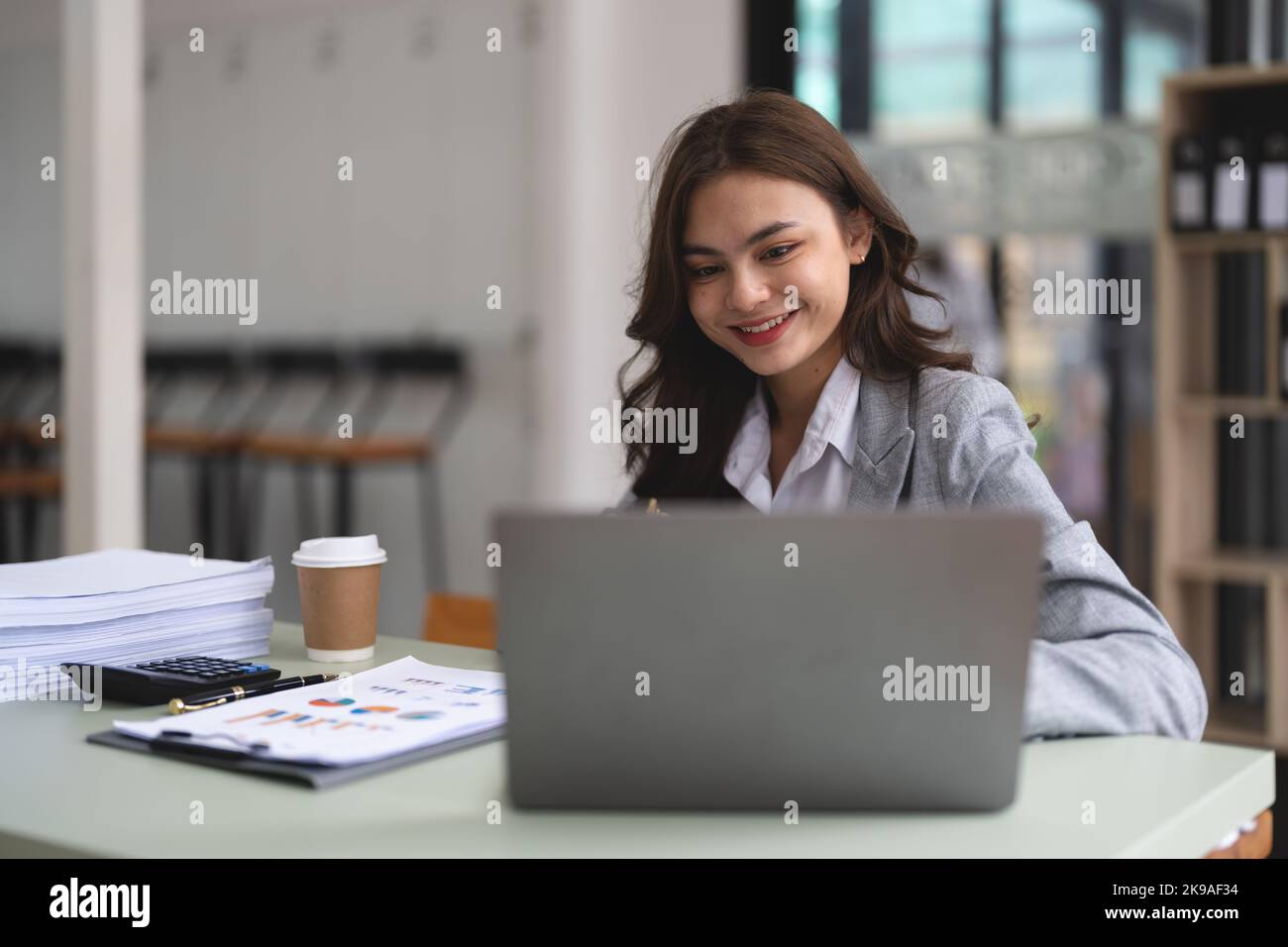 Ritratto giovane donna d'affari che lavora su computer portatile per la contabilità finanziaria grafico rapporto. Foto Stock