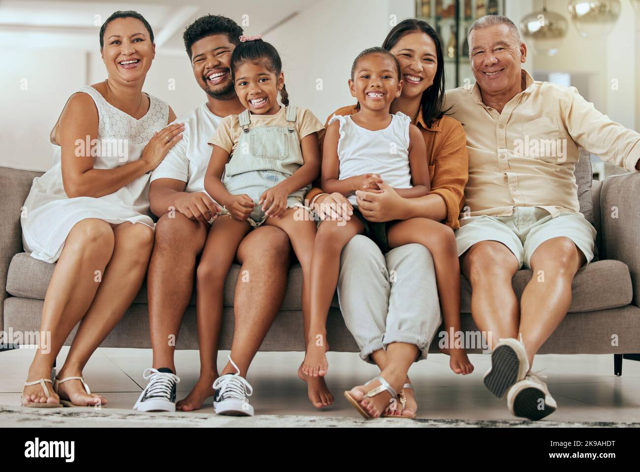 Bambini, genitori e nonni felici sul divano, generazioni di famiglia insieme in soggiorno. Amore, casa e coppia con i bambini, nonna e nonno Foto Stock