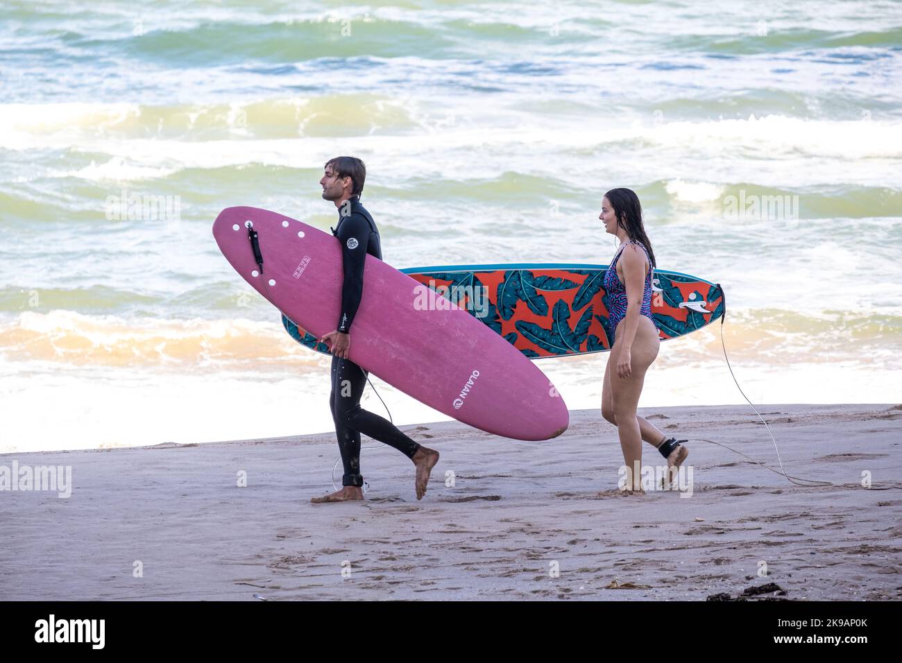 Valencia, Spagna; 12th ottobre 2022: Due surfisti camminano lungo la riva con le loro tavole da surf. Foto Stock
