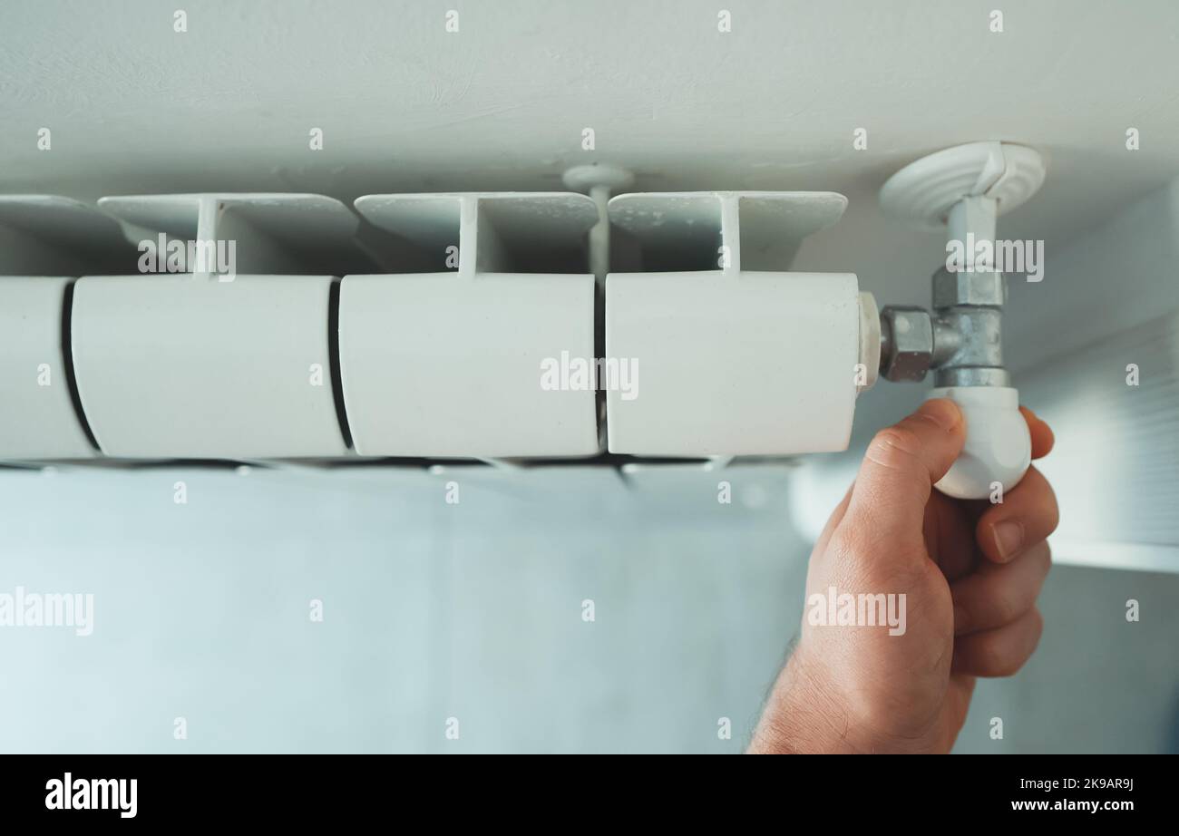 Maschio lato termostato di regolazione per attivare il riscaldatore del radiatore a casa. Foto Stock