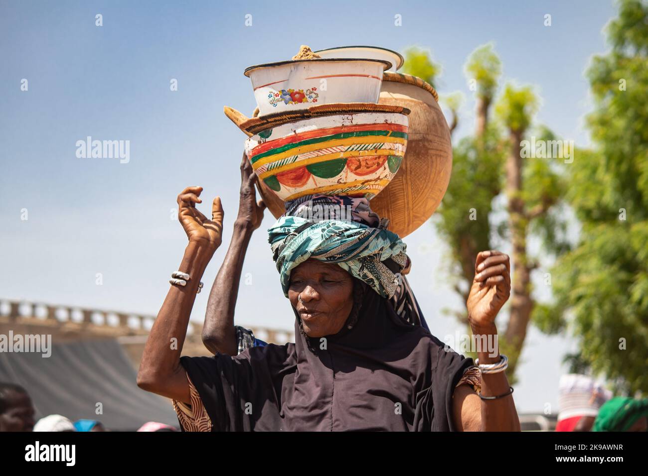 Tribù africane, Nigeria, Stato di Borno, città di Maiduguri. Fulani tribù femmine in abiti colorati, portano vasi con l'acqua sulla testa Foto Stock