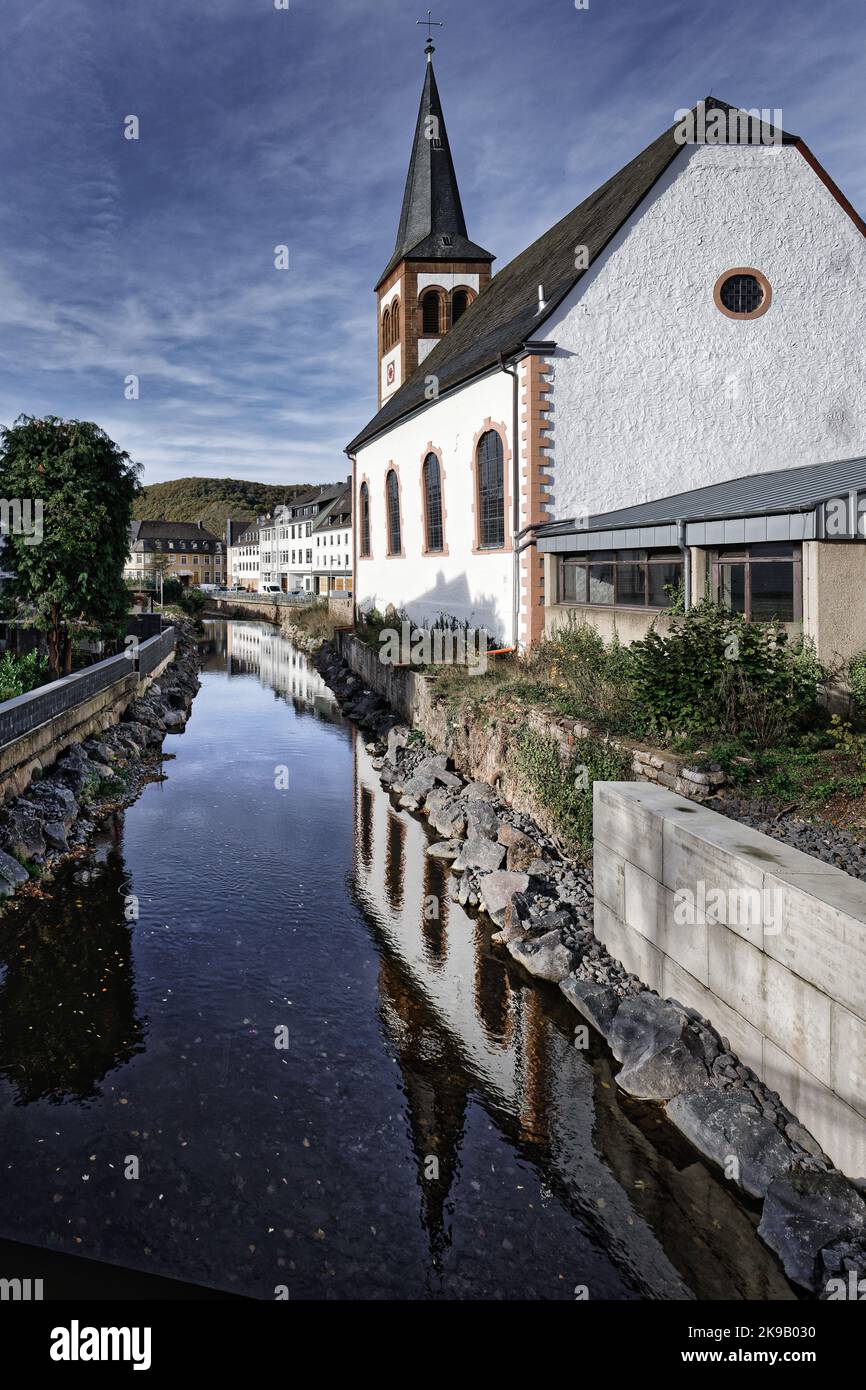 la romantica chiesa evangelica della trinità si riflette nel fiume urft nel gemuend tedesco della città di eifel Foto Stock