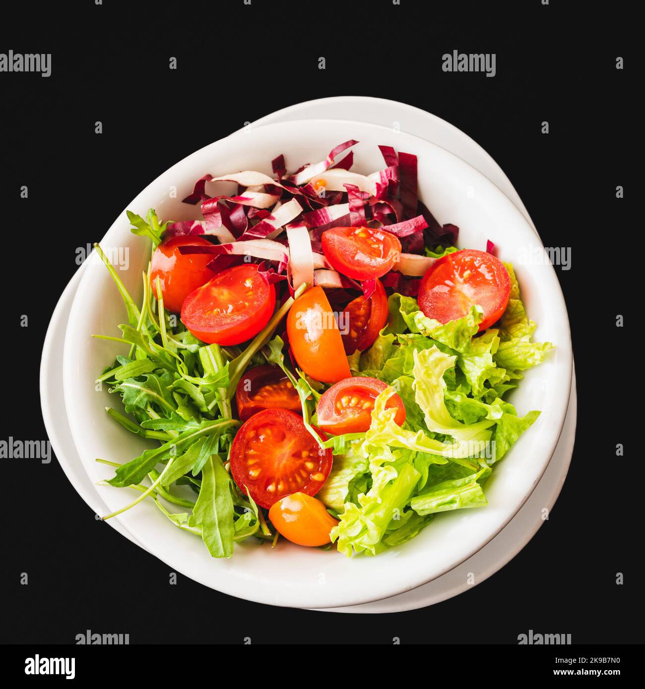 Insalata mista con lattuga, pomodoro e foglie di rucola fresca. Piatto vegetariano. Foto Stock