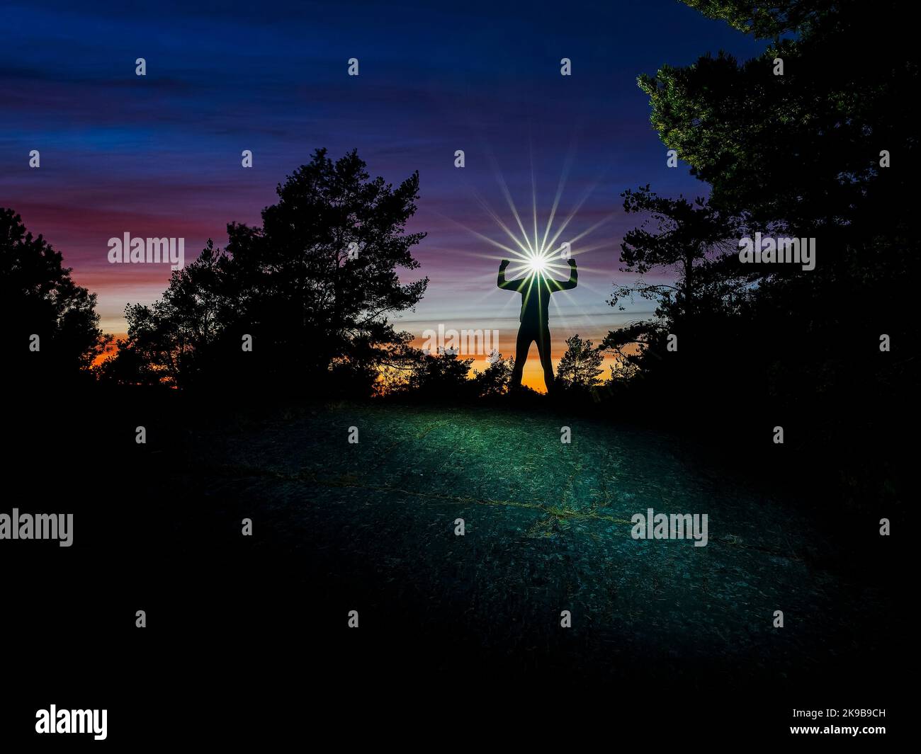 Corridore con faro in piedi nella foresta al tramonto Foto Stock
