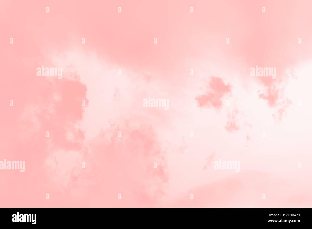 Nuvole di colore corallo rosa su uno sfondo di cielo rosa pallido Foto Stock