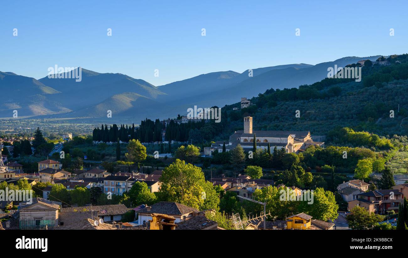 Tramonto panoramico: Vista sul tetto della periferia di Spoleto con case in pietra tradizionali, hotel San Ponziano e montagne. Umbria, Italia. rapporto 16:9:1 Foto Stock