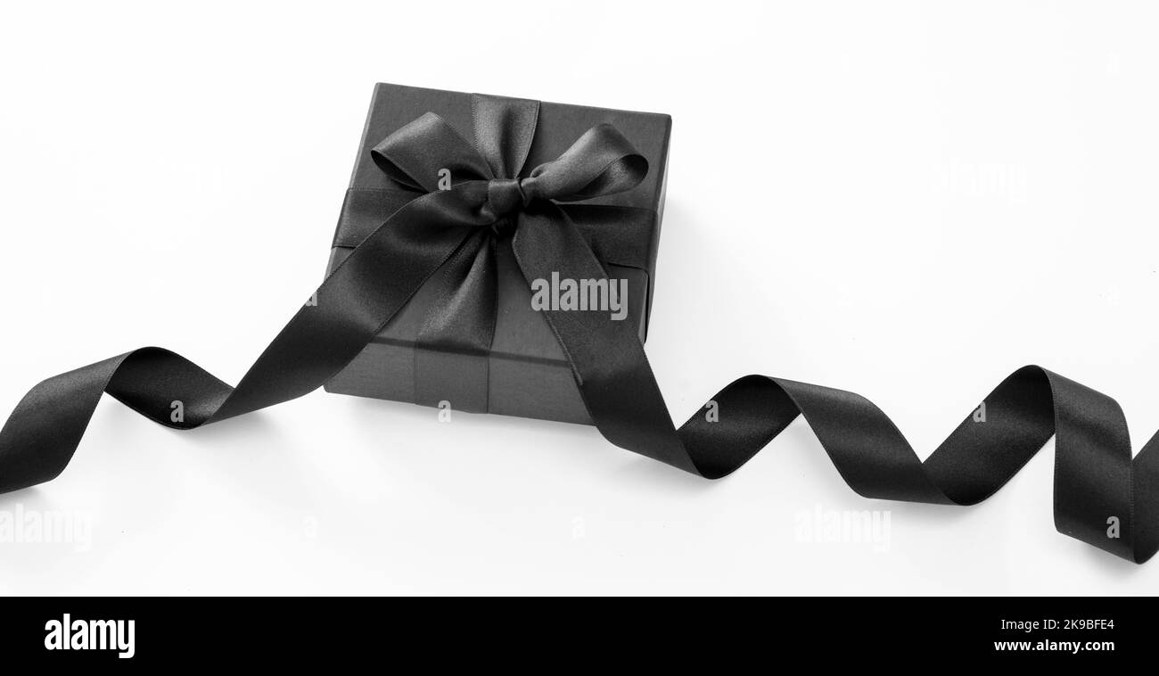 Vendita Black Friday e regali di Natale concept. Confezione regalo con nastro nero isolato su sfondo bianco, Foto Stock