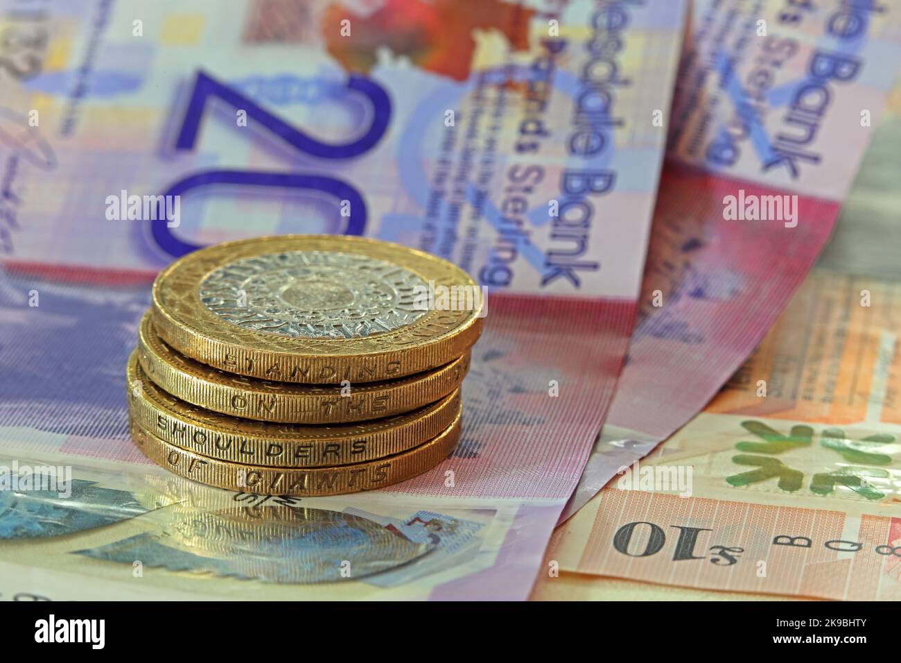 Clydesdale, banconote in sterline, con due monete da lire che riportano l'iscrizione "in piedi sulle spalle dei giganti". Monete e banconote in contanti Foto Stock