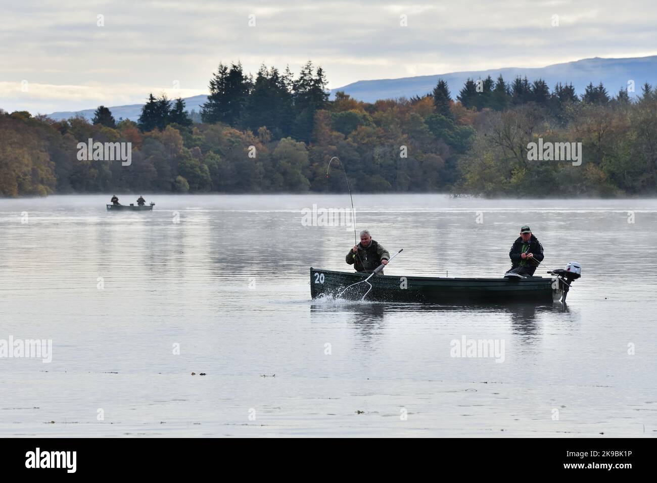 Una fredda mattina viscida durante l'autunno vede i pescatori portare un pesce sulla rete al lago di Menteith, Stirlingshire, Scozia, Regno Unito Foto Stock