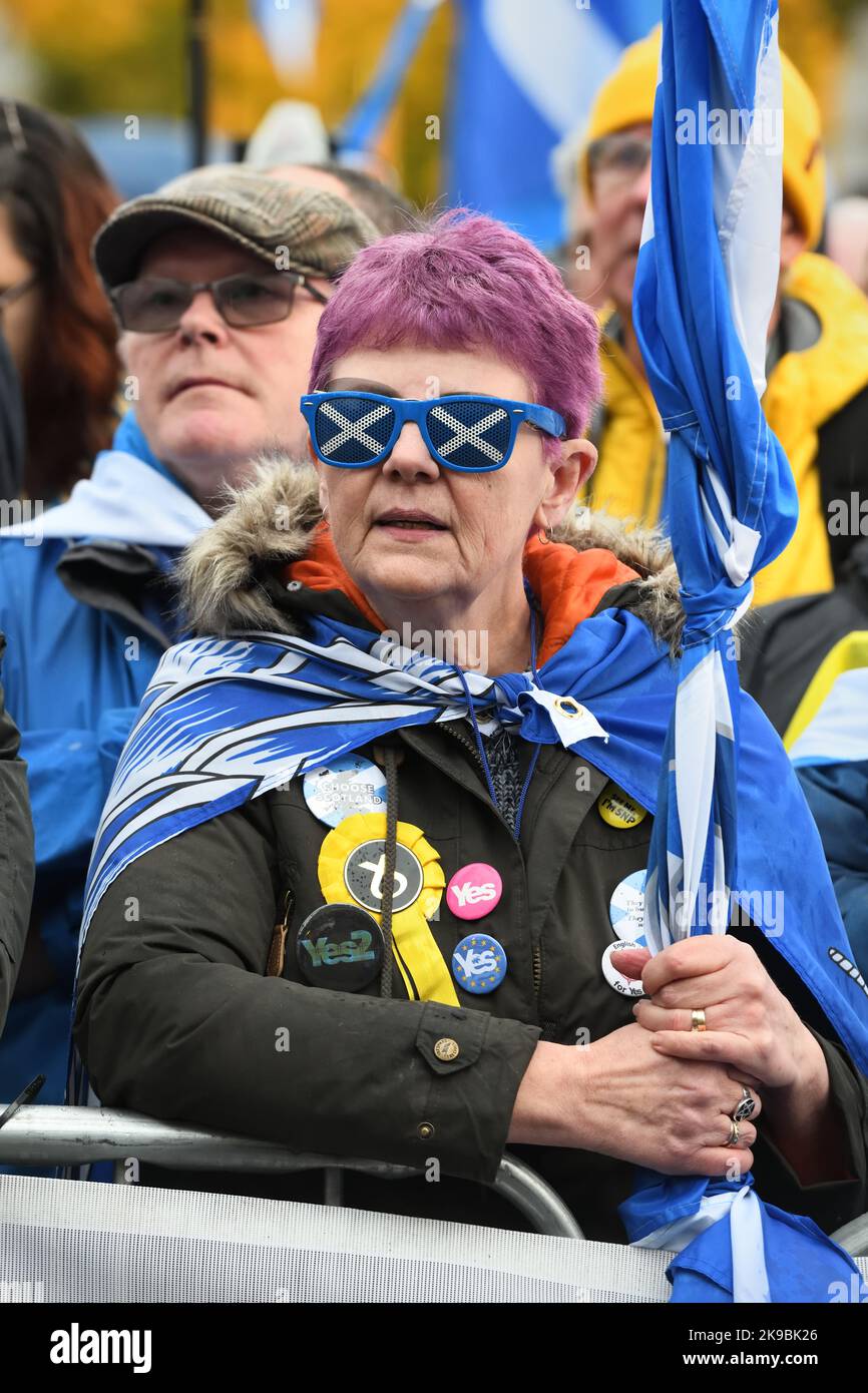 Un SNP e un sostenitore dell'indipendenza che indossano occhiali da sole con bandiera scozzese in un raduno a Glasgow, Scozia. Foto Stock
