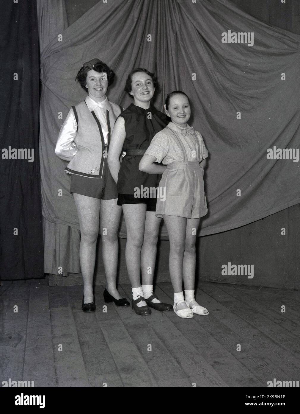 1955, storico, febbraio, tre ragazze che appaiono nel pantomino, Robin Hood, posando su un palco di legno nei loro costumi per una foto, Leeds, Inghilterra, Regno Unito. Foto Stock
