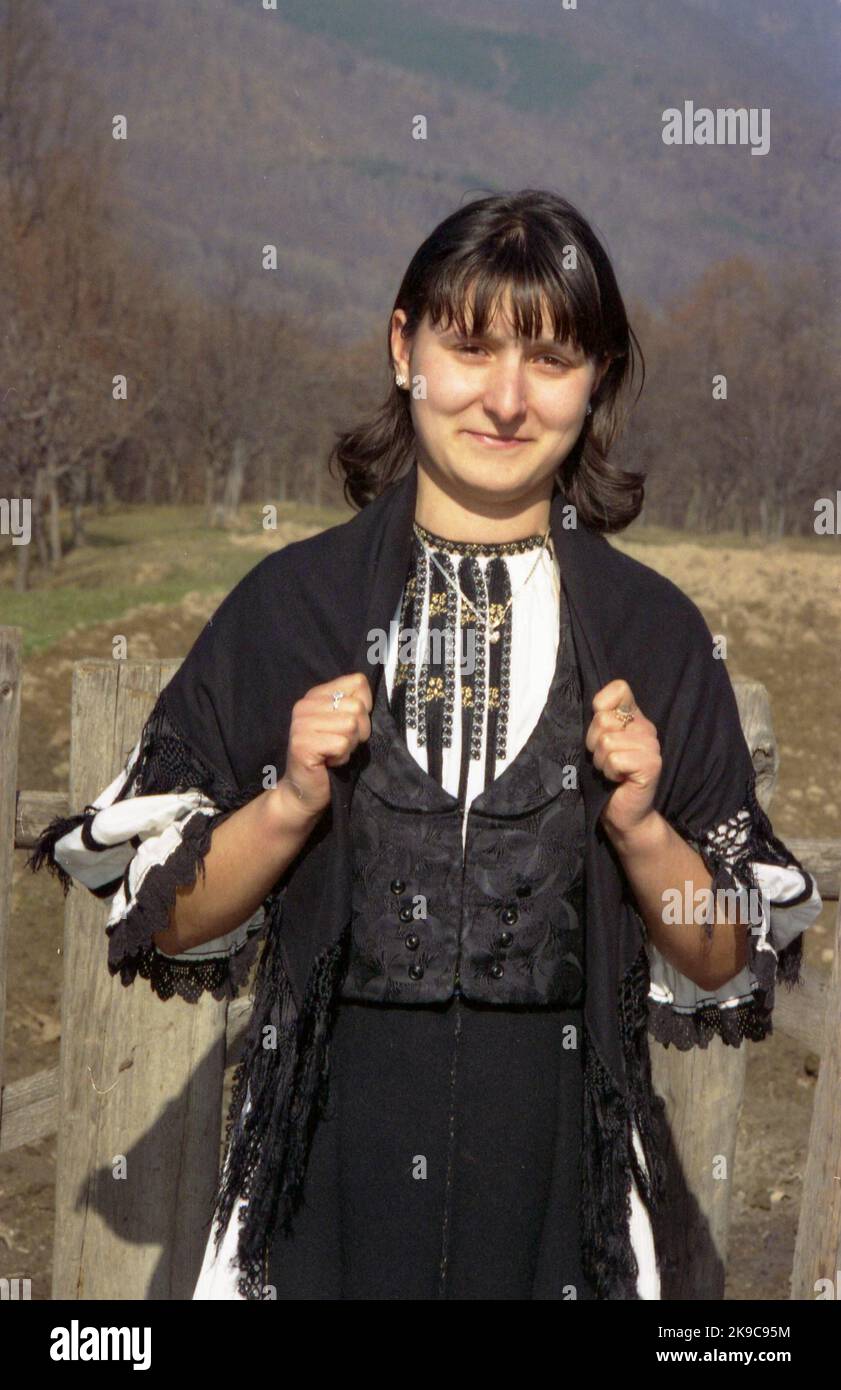 Gorj County, Romania, circa 2000. Giovane donna in un bel vestito tradizionale locale. Foto Stock