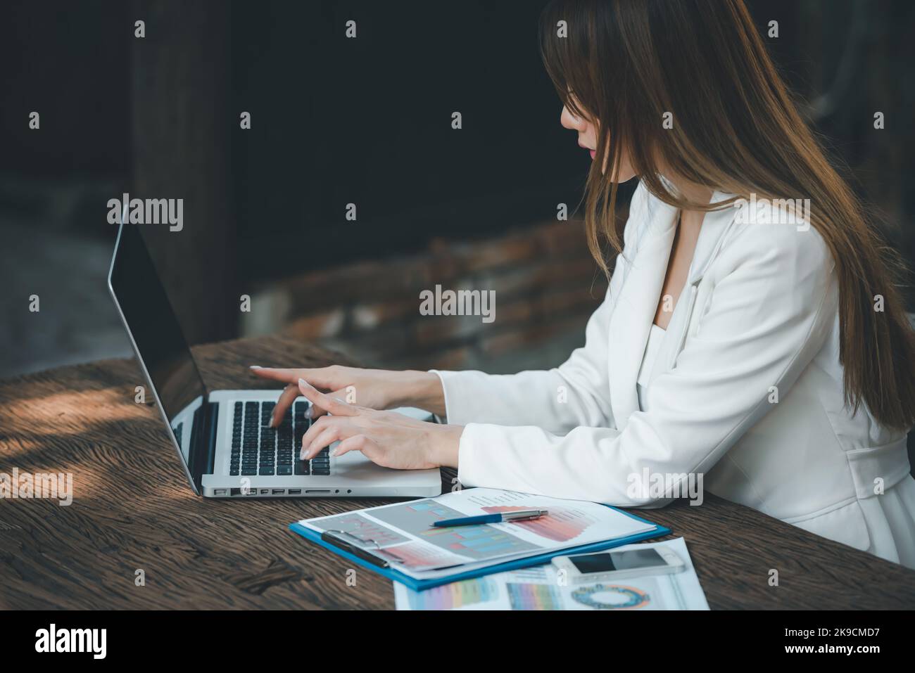 Giovane Asian Businesswoman che lavora su computer portatile con grafici finanziari grafici , utilizzando il software di conto commerciale per l'analisi dei dati e il progetto mana Foto Stock