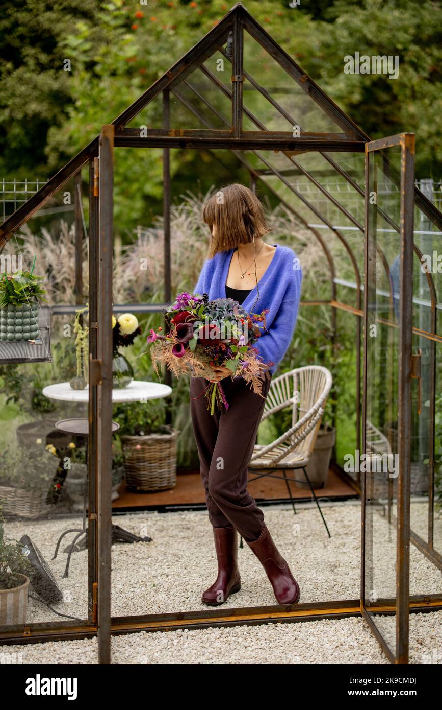 Donna con bouquet di fiori in giardino Foto Stock