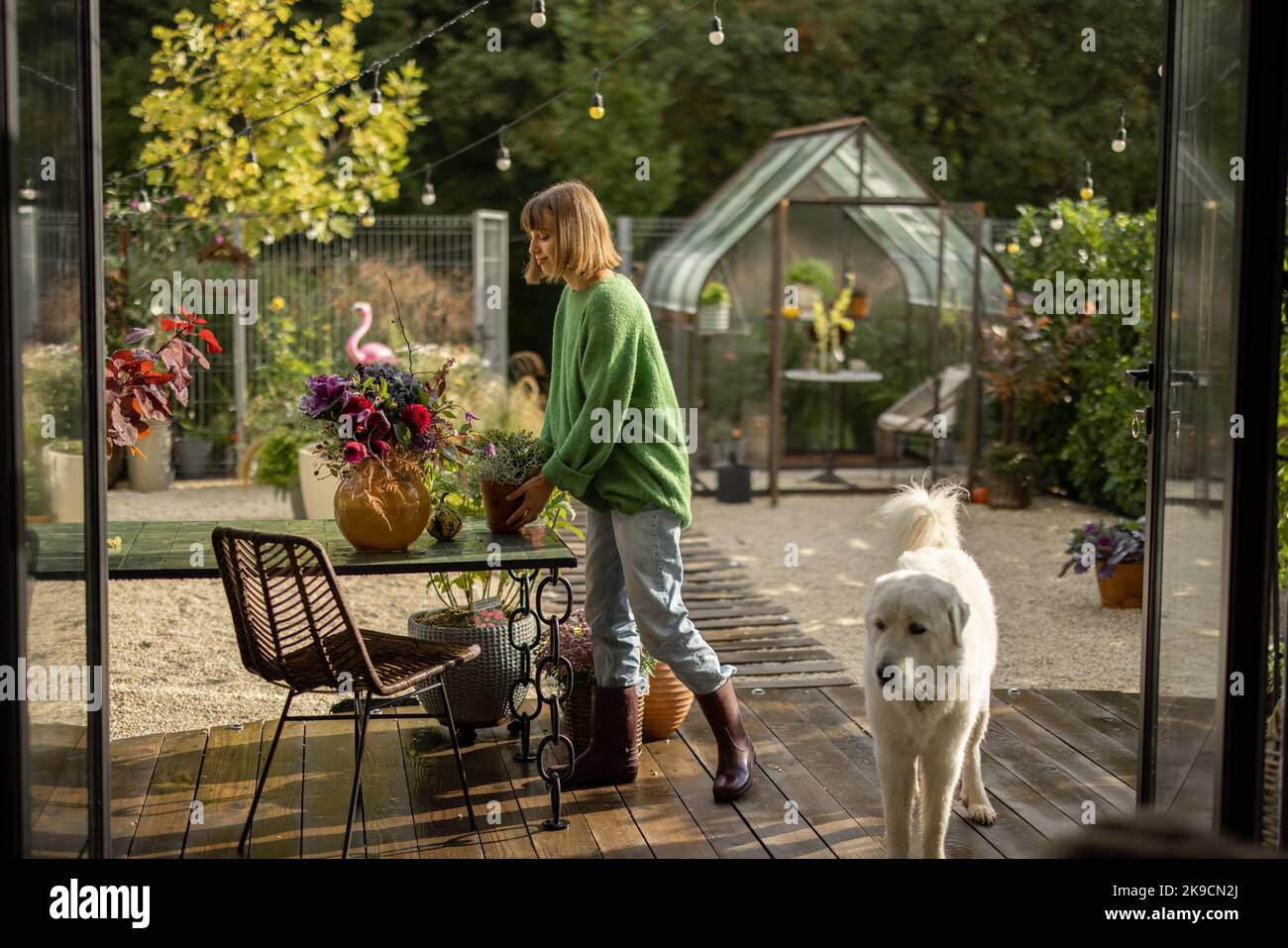 Donna con fiori sul cortile Foto Stock