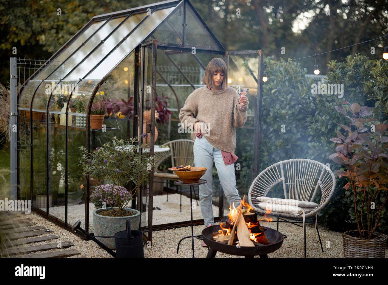 La donna trascorre la serata in un accogliente giardino Foto Stock