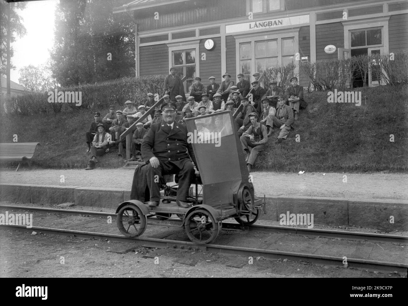 Personale e dressin fuori dalla stazione nome precedente 'Långbanshyttan'. La stazione è stata costruita nel 1890. Edificio in legno a uno e mezzo piano. L'appartamento residenziale è stato rimodernato nel 1946. Aperto nel 1/11 1889, il nome è stato cambiato da 'Långbanshyttan' a 'Långban' 15/9 1920. Luogo di tenuta e di carico, quindi fermarsi 17/6 1974. Chiuso il 2/9 1985 Foto Stock