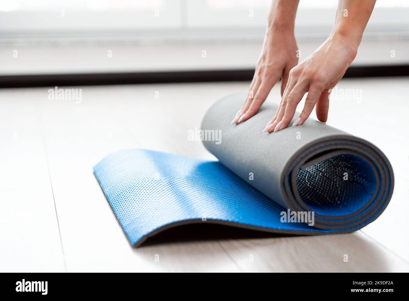 Donna pieghevole tappetino yoga, allenamento a casa concetto Foto Stock