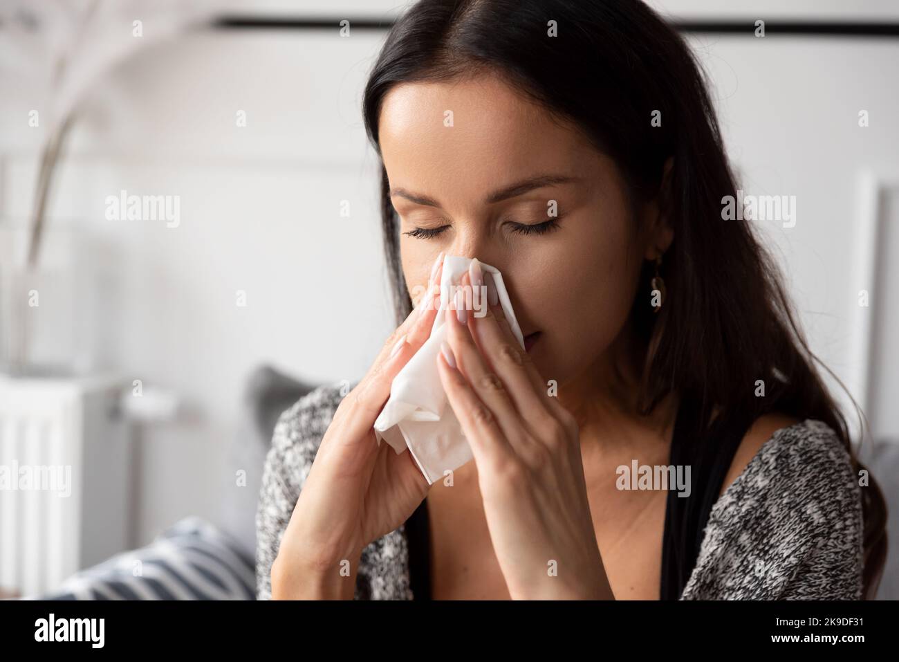 Donna malata che soffia il naso. Donna preso freddo. Foto Stock