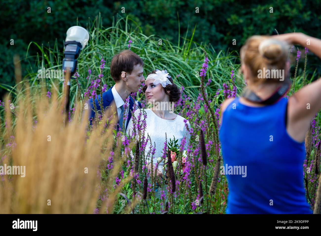 08-12-2014 Mosca, Russia. Fotografia di nozze nel giardino botanico - donna fotografo che fa il ritratto di sposa e sposo Foto Stock