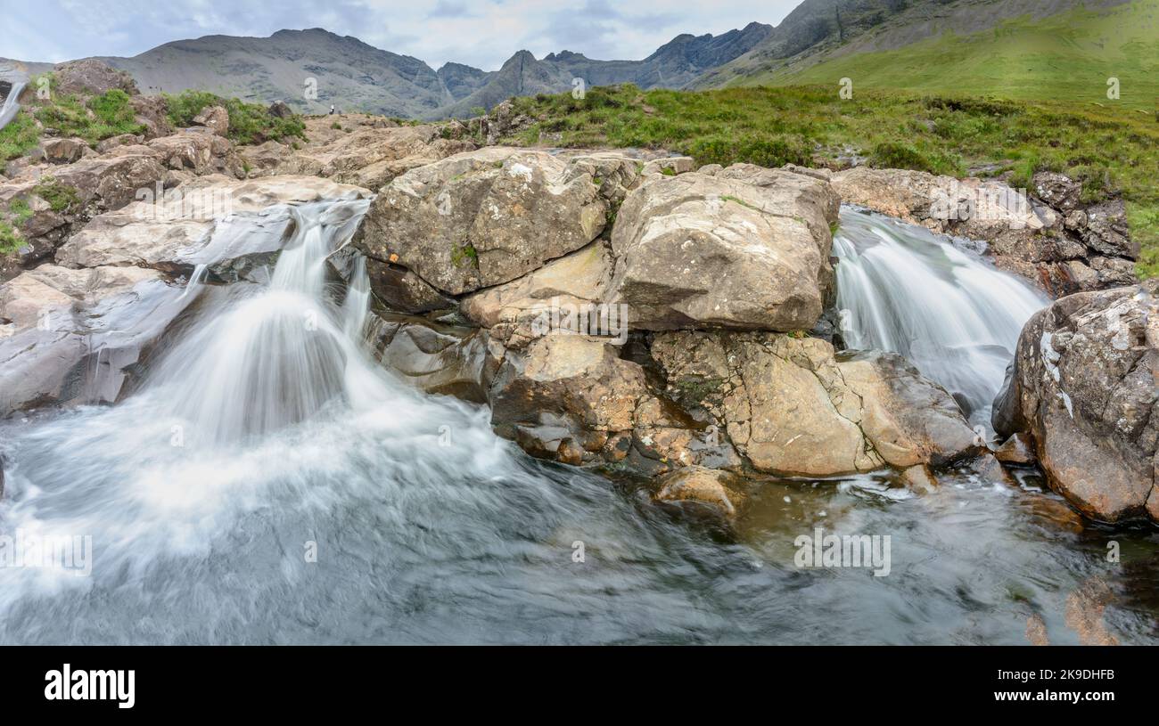 Lunga fila di cascate e piscine rocciose di montagna ai piedi delle Black Cuillin Mountains, popolare sito turistico, spettacolare scenario Skye, un sentiero ripido Foto Stock