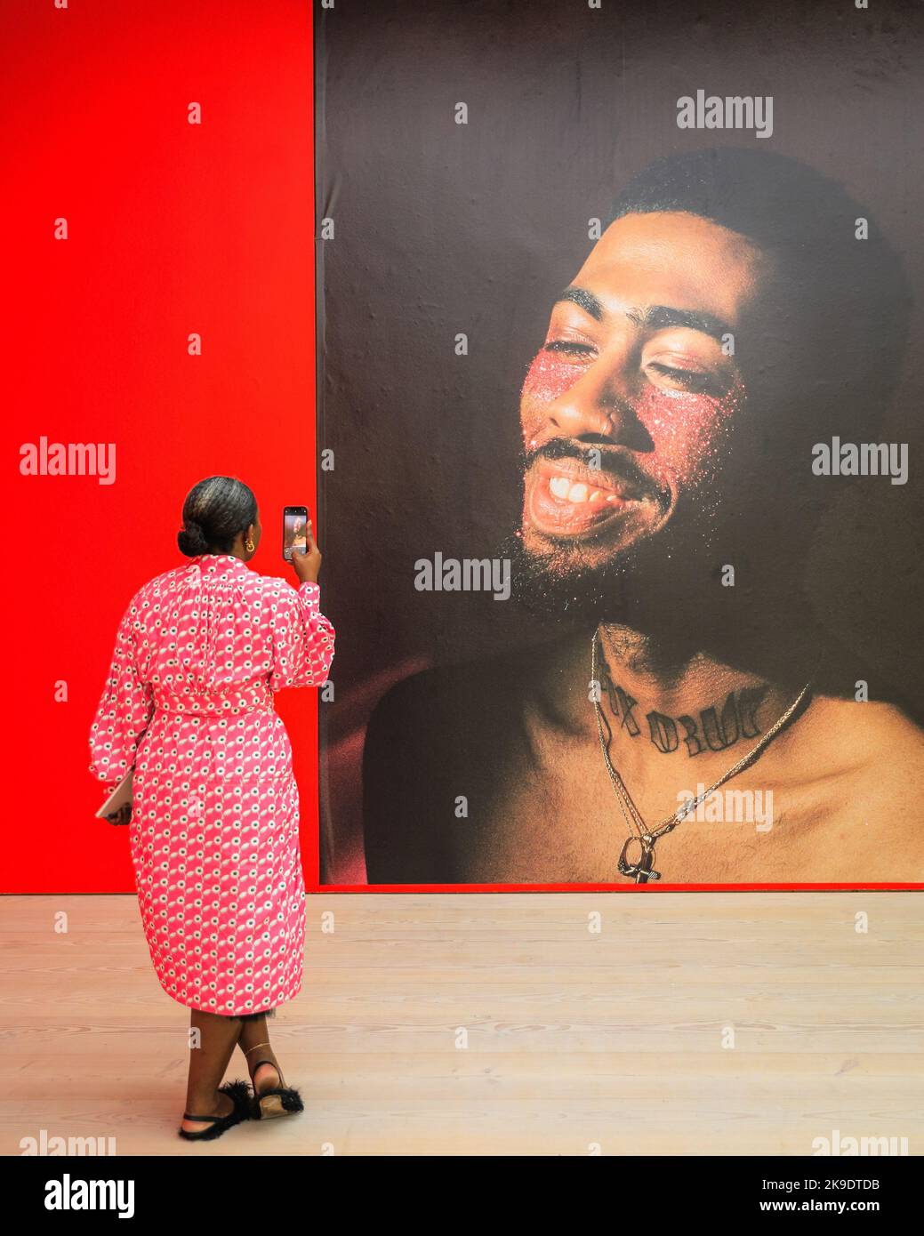 Londra, Regno Unito. 27th Ott 2022. Un giornalista scatta foto di una foto di Quil Lemon che presenta il modello Isaia 'Teddy' Write, tratto dalla Glitterboy Series, 2017. Gli ospiti e gli artisti invitati si mescolano e si posano con le immagini. Vista privata della nuova mostra "The New Black Vanguard: Photography between Art and Fashion" alla Saatchi Gallery di Londra, con il sostegno di Burberry. La mostra comprende 15 fotografi neri internazionali ed è una celebrazione della creatività nera sia davanti che dietro la fotocamera, in esecuzione fino al 22 gennaio 2023. Credit: Imageplotter/Alamy Live News Foto Stock