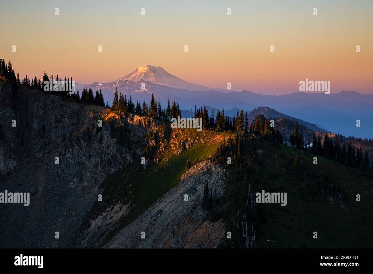 WA22597-00...WASHINGTON - alba colorata sulle rocce di Goat e sul Monte Adams dal Crystal Peak nel Parco Nazionale di Mount Rainier. Foto Stock