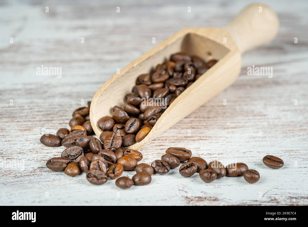 Cucchiaio di legno con chicchi di caffè pronti per macinare e gustare il loro sapore. Foto Stock