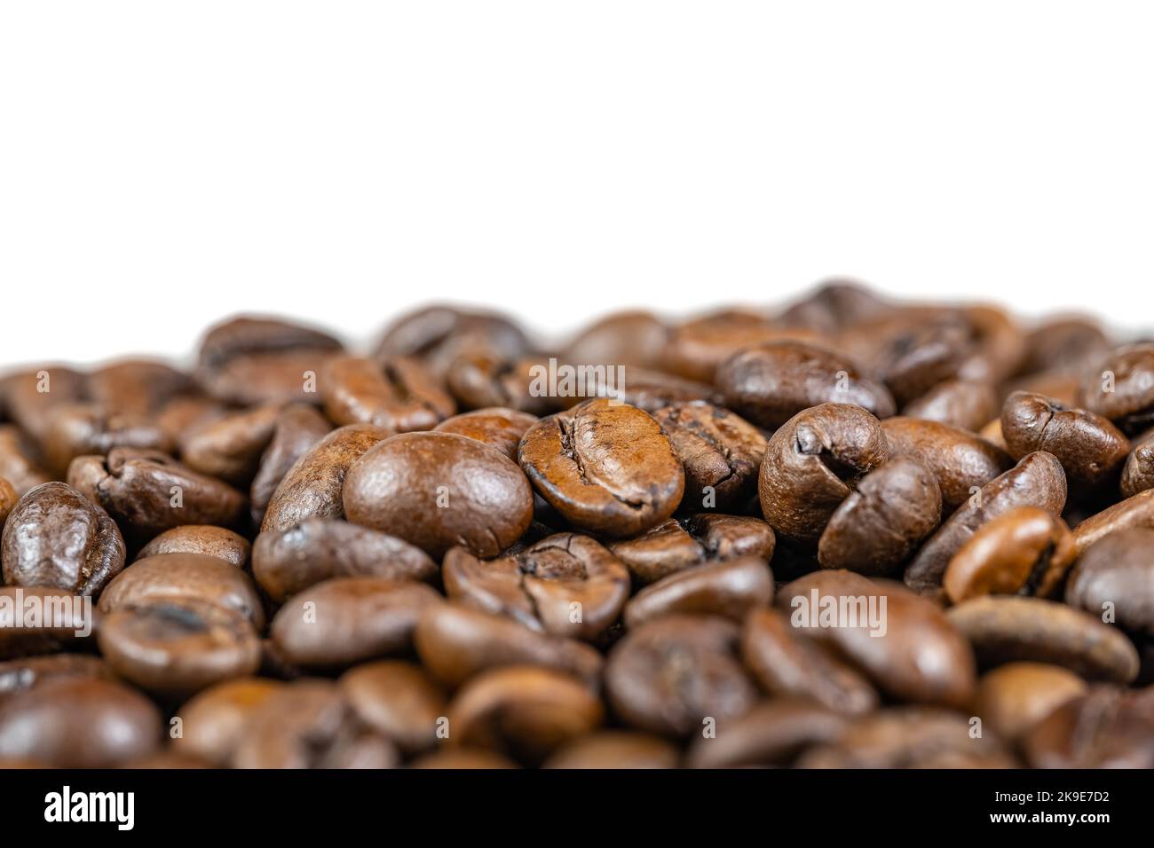 Macrofotografia di chicchi di caffè tostati naturalmente con uno spazio di copia superiore per inserire il testo. Foto Stock