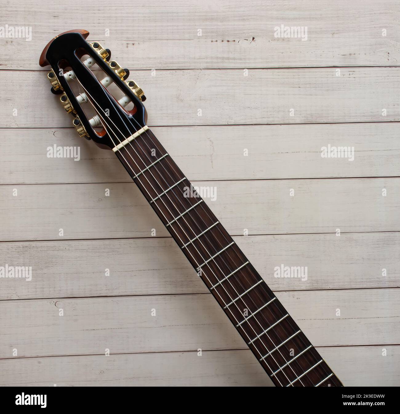 Tastiera per chitarra acustica su sfondo in legno. Spazio per il testo. Foto Stock