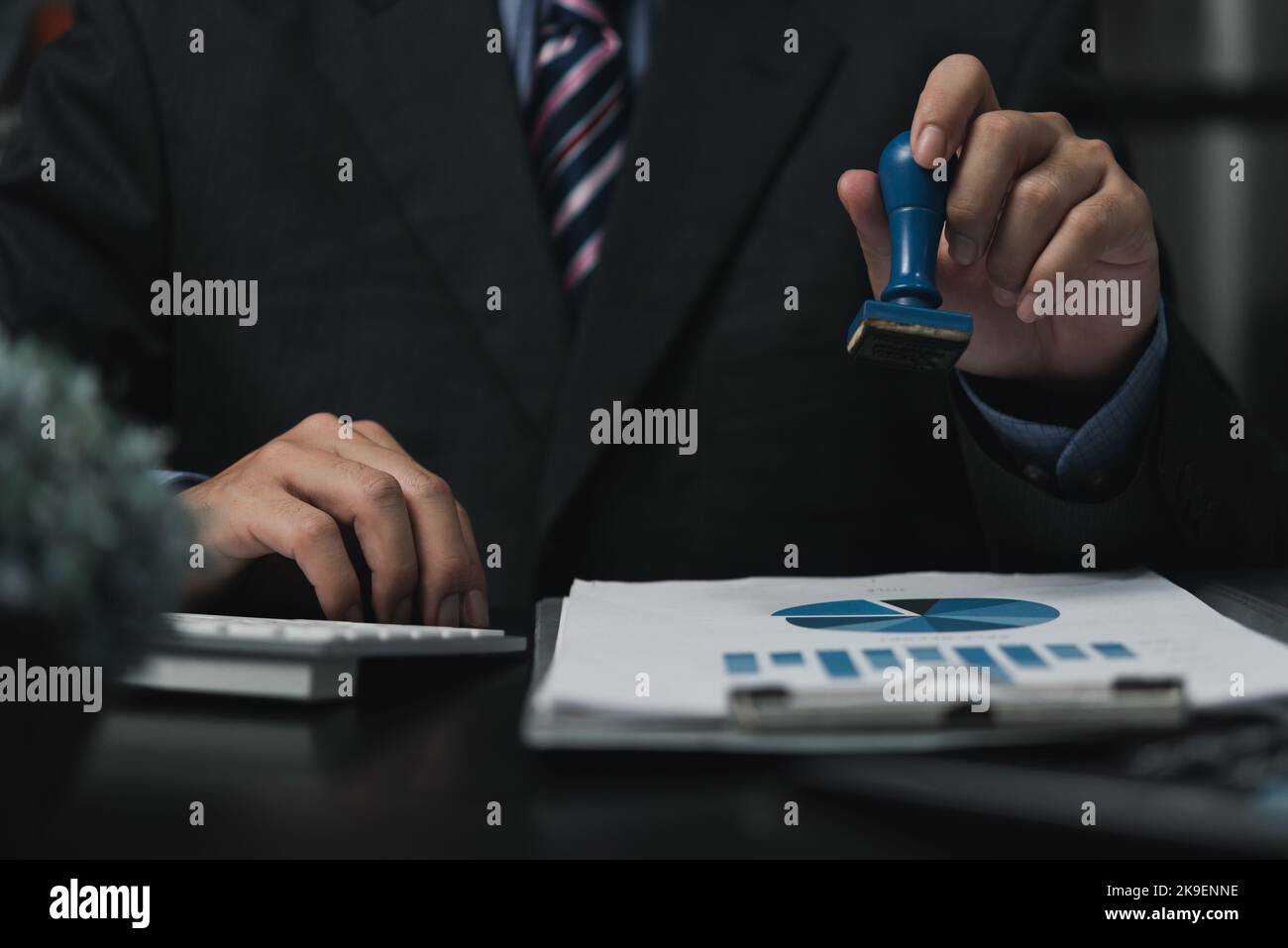 Uomo che approva i documenti di Work Finance banking o investment marketing sulla scrivania. Foto Stock