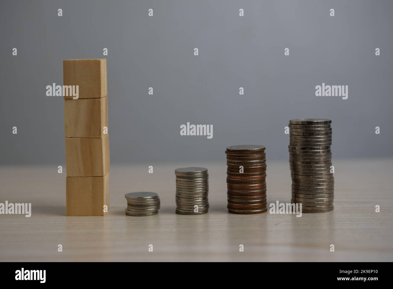 Impilare monete e blocchi di legno vuoti sulla scrivania. Foto Stock