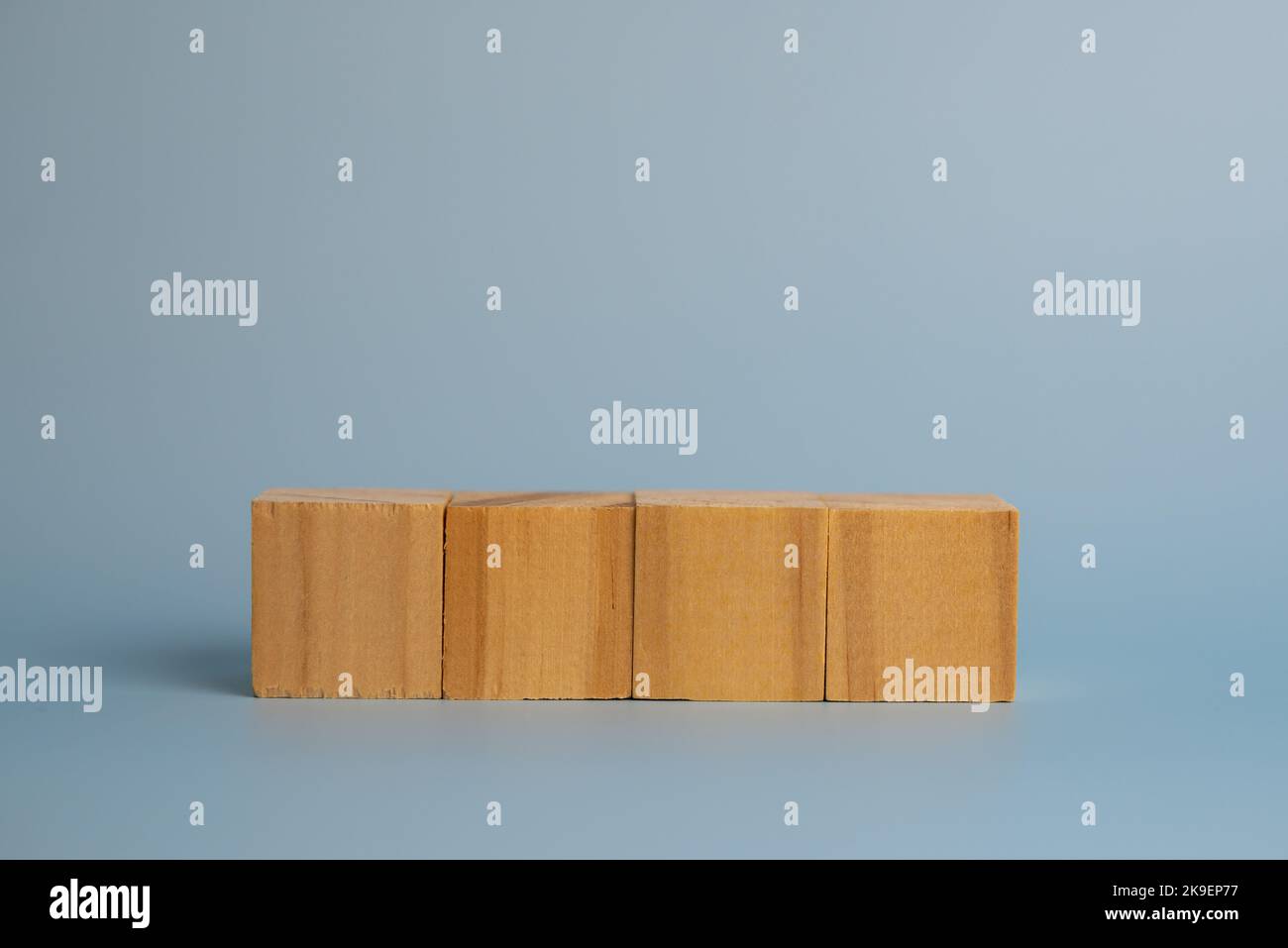 Quattro cubi di legno vuoti sullo sfondo per il testo. Modello e banner di concetto aziendale. Foto Stock