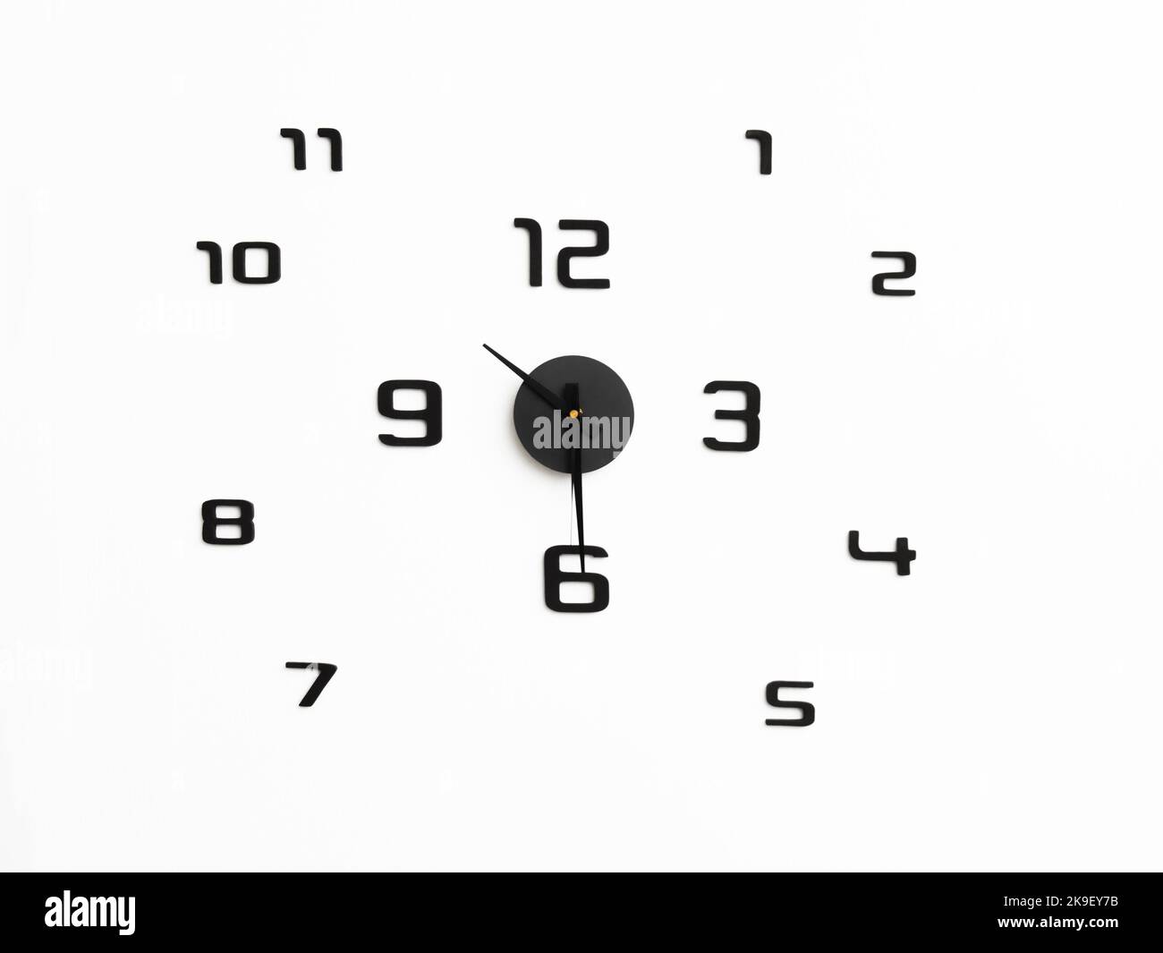 Orologio da parete dal design minimalista con numeri neri. Foto Stock