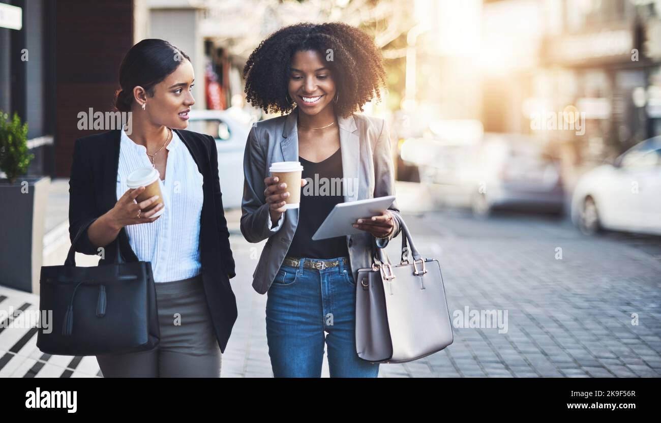 Fare loro il successo un passo alla volta. Due donne d'affari che hanno una discussione mentre camminano nella città. Foto Stock