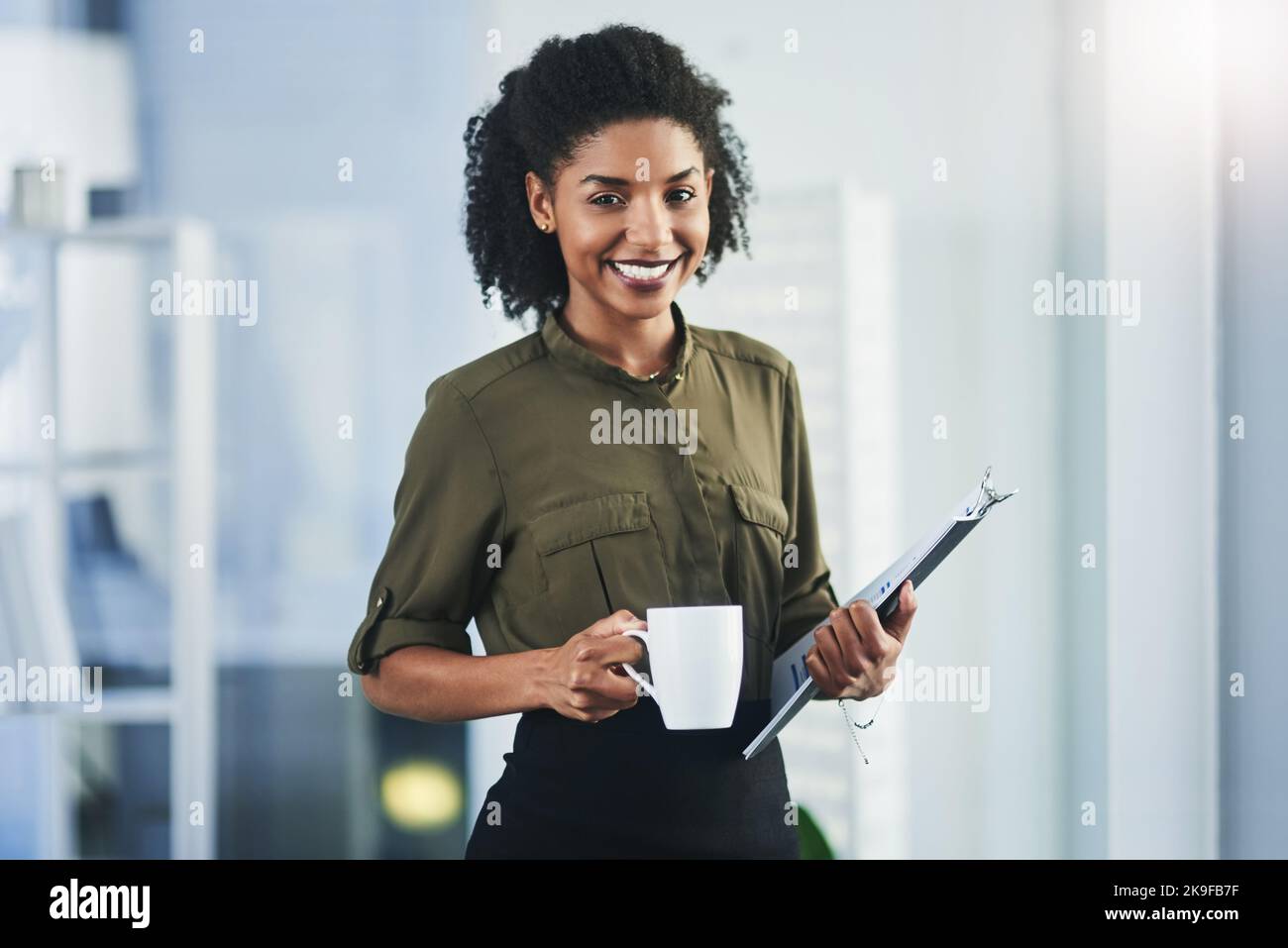 Sempre pronti per nuove sfide. Ritratto di una giovane donna d'affari che tiene una tazza di caffè e un tablet digitale nel suo ufficio. Foto Stock