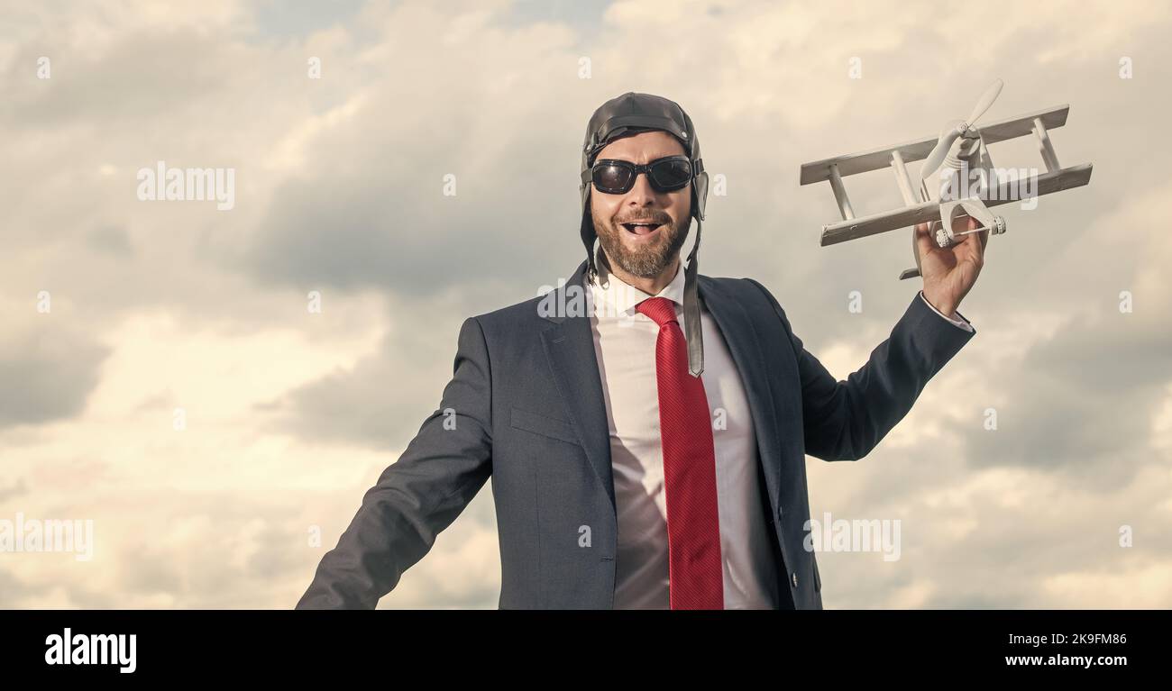 felice uomo d'affari in vestito e cappello pilota lancio aereo giocattolo Foto Stock
