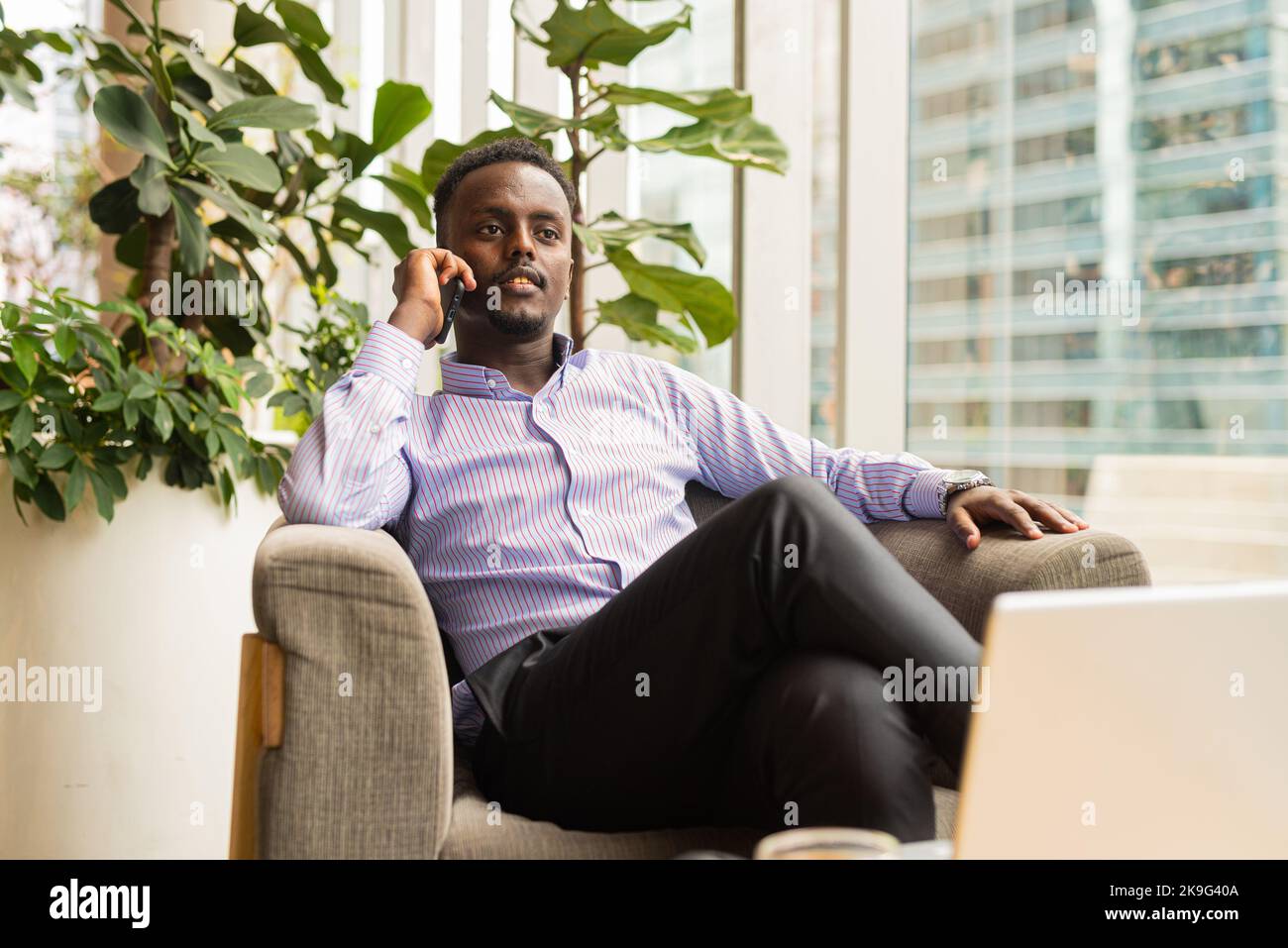Ritratto di bell'uomo d'affari africano seduto in una caffetteria Foto Stock