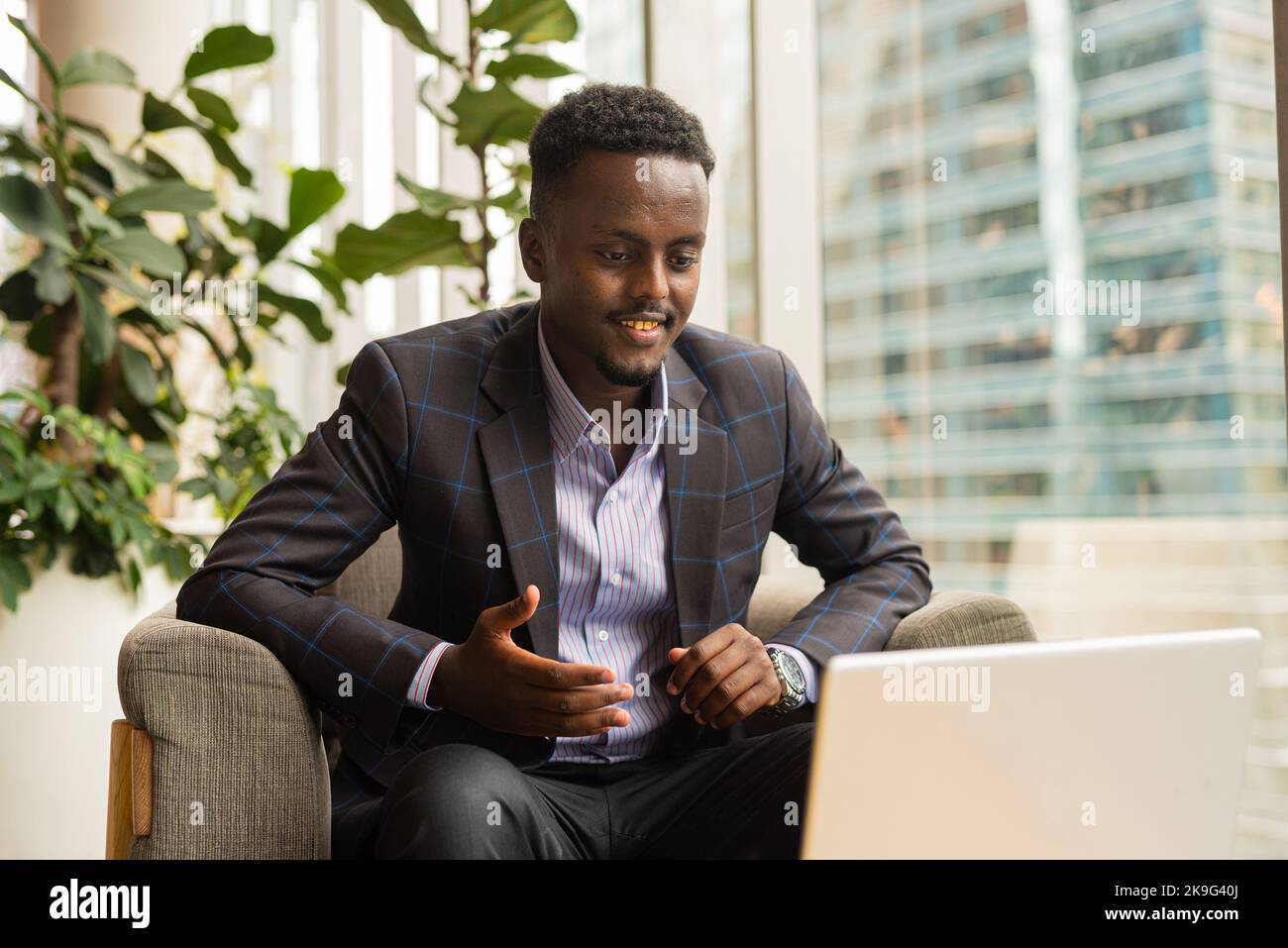 Ritratto di un uomo d'affari africano seduto in una caffetteria utilizzando un computer portatile Foto Stock