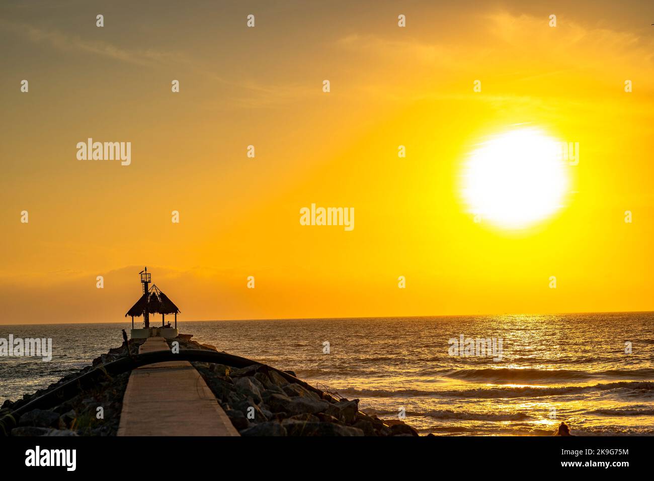 Un vecchio molo rotto con uno sfondo dorato tramonto Foto Stock