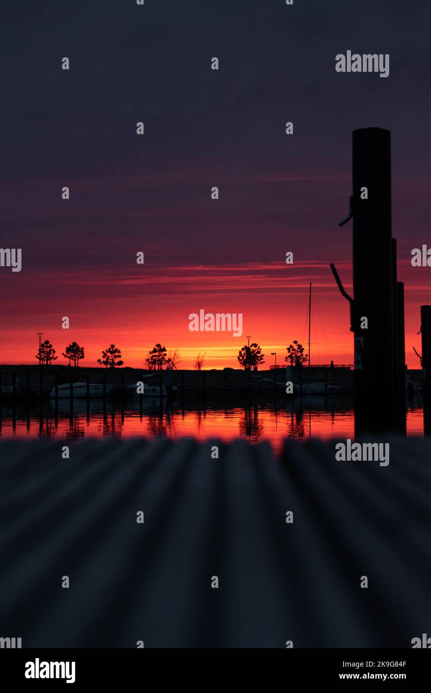 Una vista panoramica del porto di Fehmarn e degli alberi durante un tramonto spettacolare nello Schleswig-Holstein, Germania Foto Stock