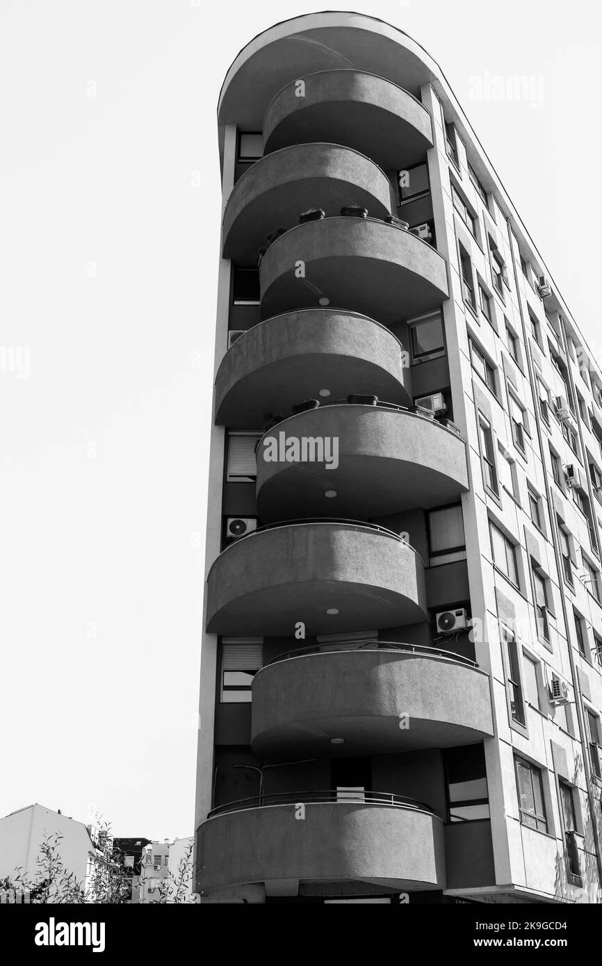Un alto e moderno edificio a torre nella citta' di Skopje, capitale della Macedonia del Nord, ex Jugoslavia. Edificio opaco e grigio, condominio. Foto Stock