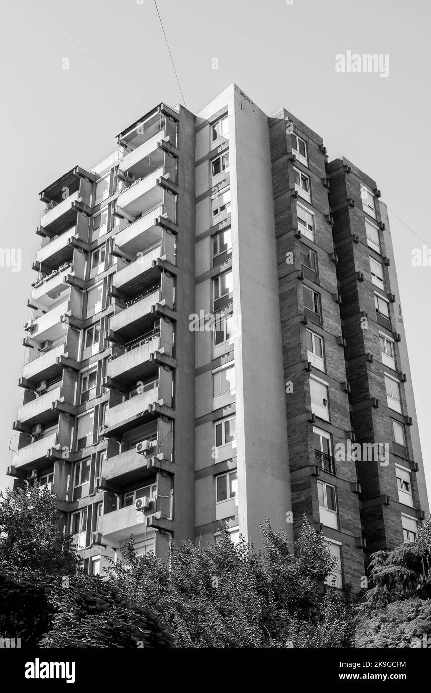 Un alto e moderno edificio a torre nella citta' di Skopje, capitale della Macedonia del Nord, ex Jugoslavia. Edificio opaco e grigio, condominio. Foto Stock