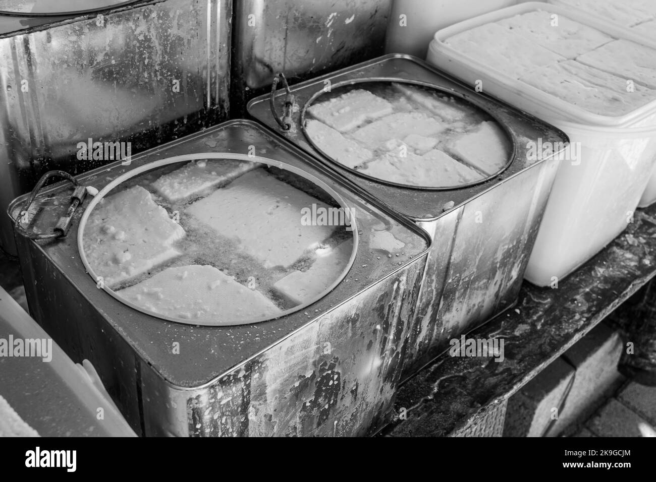 Formaggi e latticini in vendita presso uno stallo nel mercato aperto della città di Tetovo nel nord della Macedonia. Articoli freschi in vendita in contenitori e scatole. Foto Stock