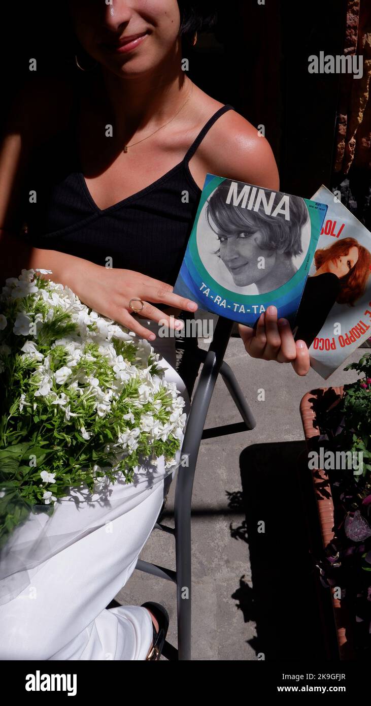 Una ragazza caucasica con due dischi in vinile della cantante italiana Mina Foto Stock