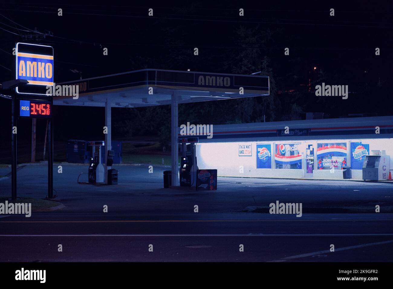 una stazione di servizio di notte in colori blu Foto Stock