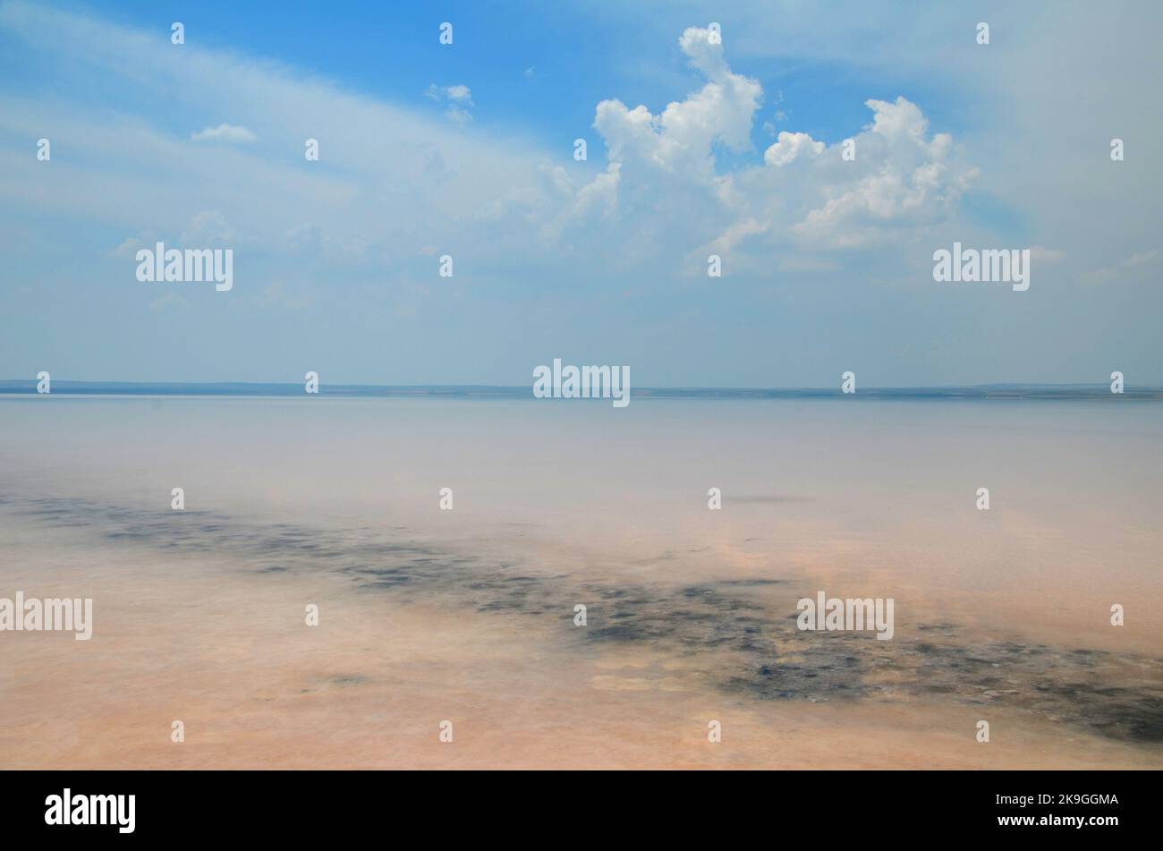 Affascinante gioco di colori del lago salato 'Tuz Gölü' sotto il cielo blu Foto Stock
