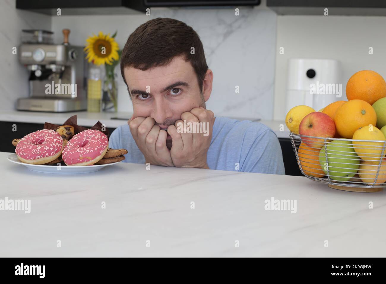 Uomo che decide tra cibo sano o non sano Foto Stock